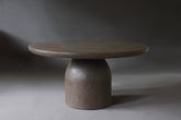 Nexus Round Dining Table in Pebble micro cement finish, showcasing its sleek design and smooth texture.